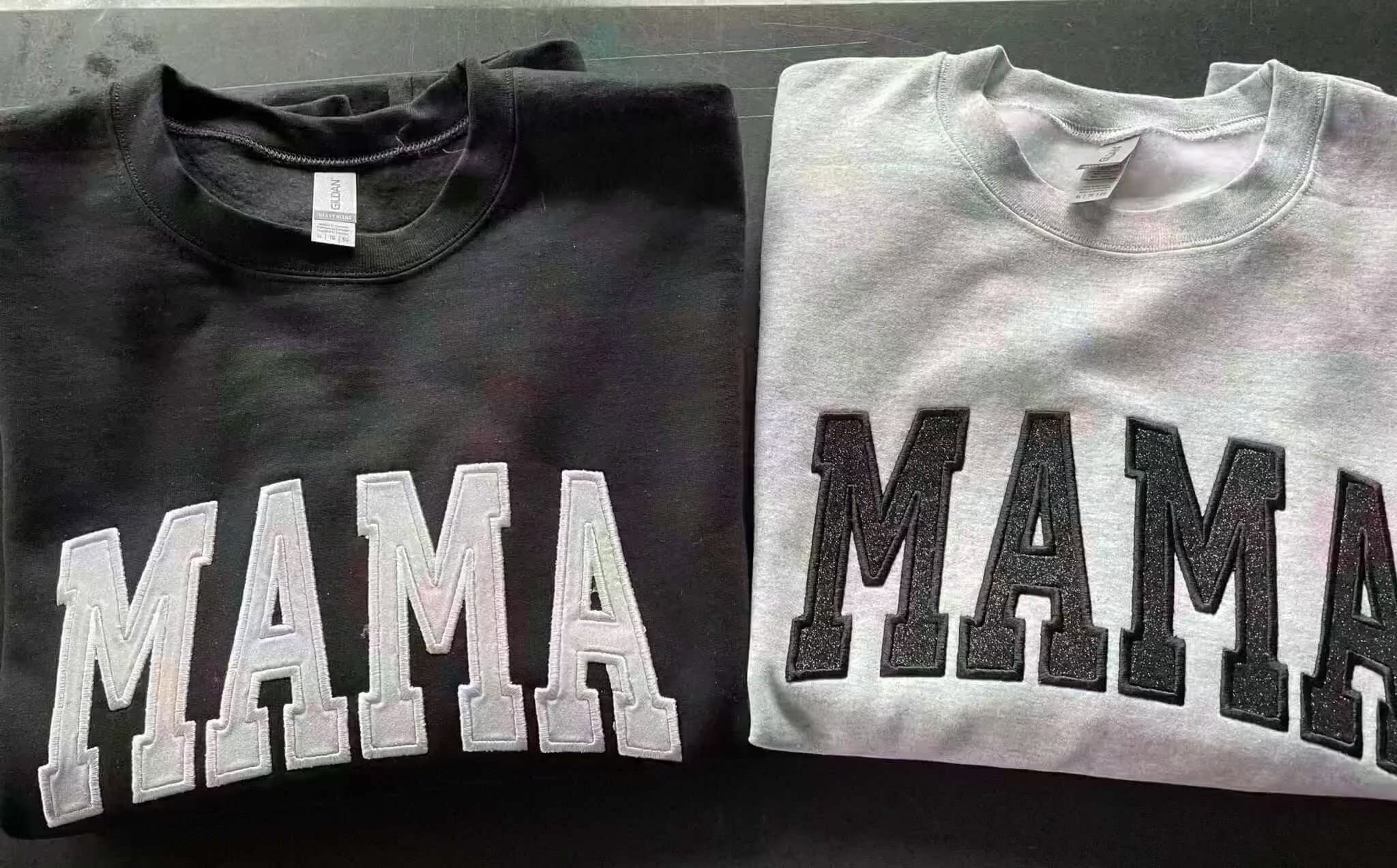 Black and gray crewneck sweatshirts with embroidered "MAMA" design in glitter letters, personalized gift for mothers