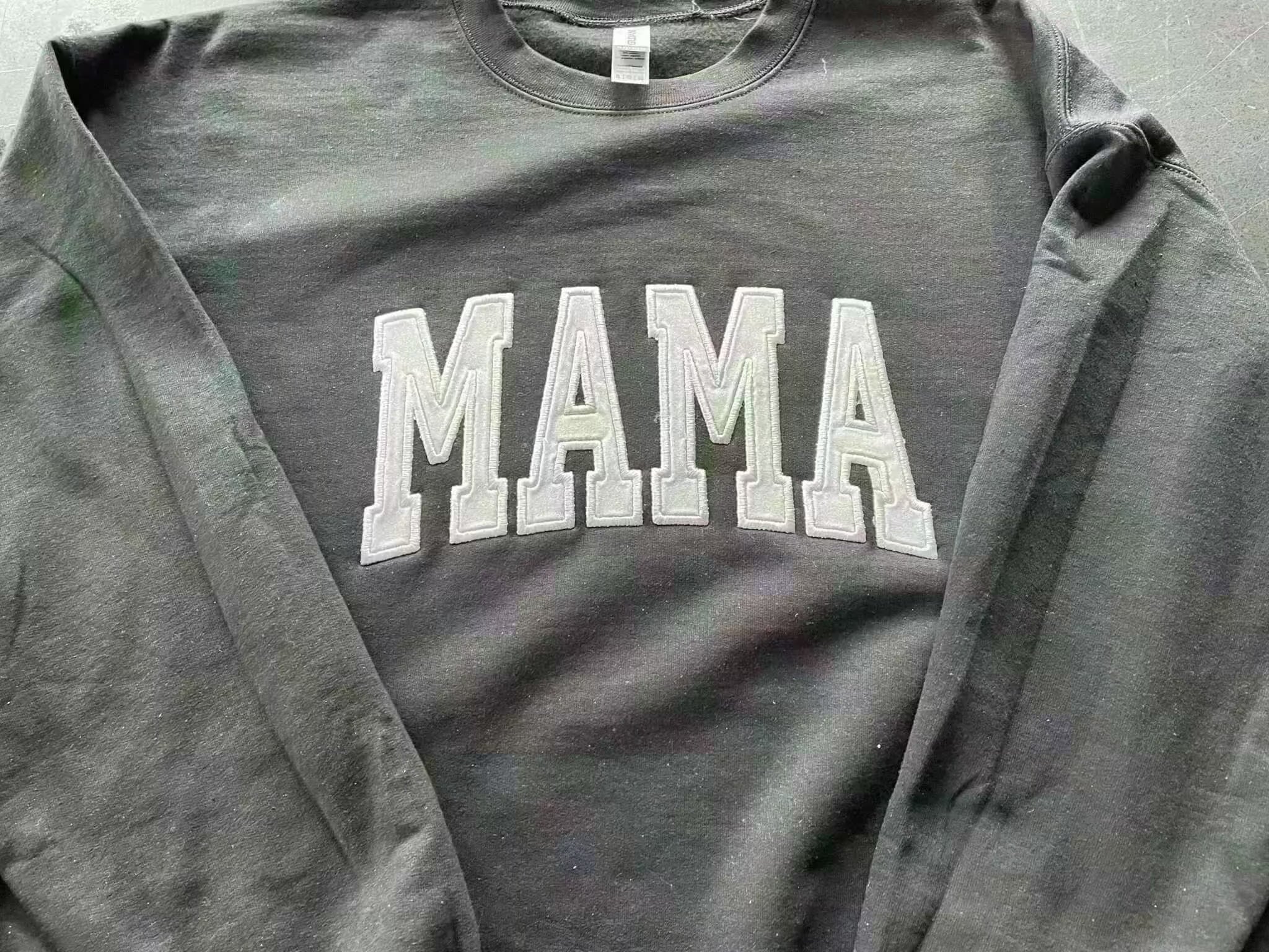 Gray Gildan crewneck sweatshirt with embroidered glitter HTV "MAMA" design in white letters