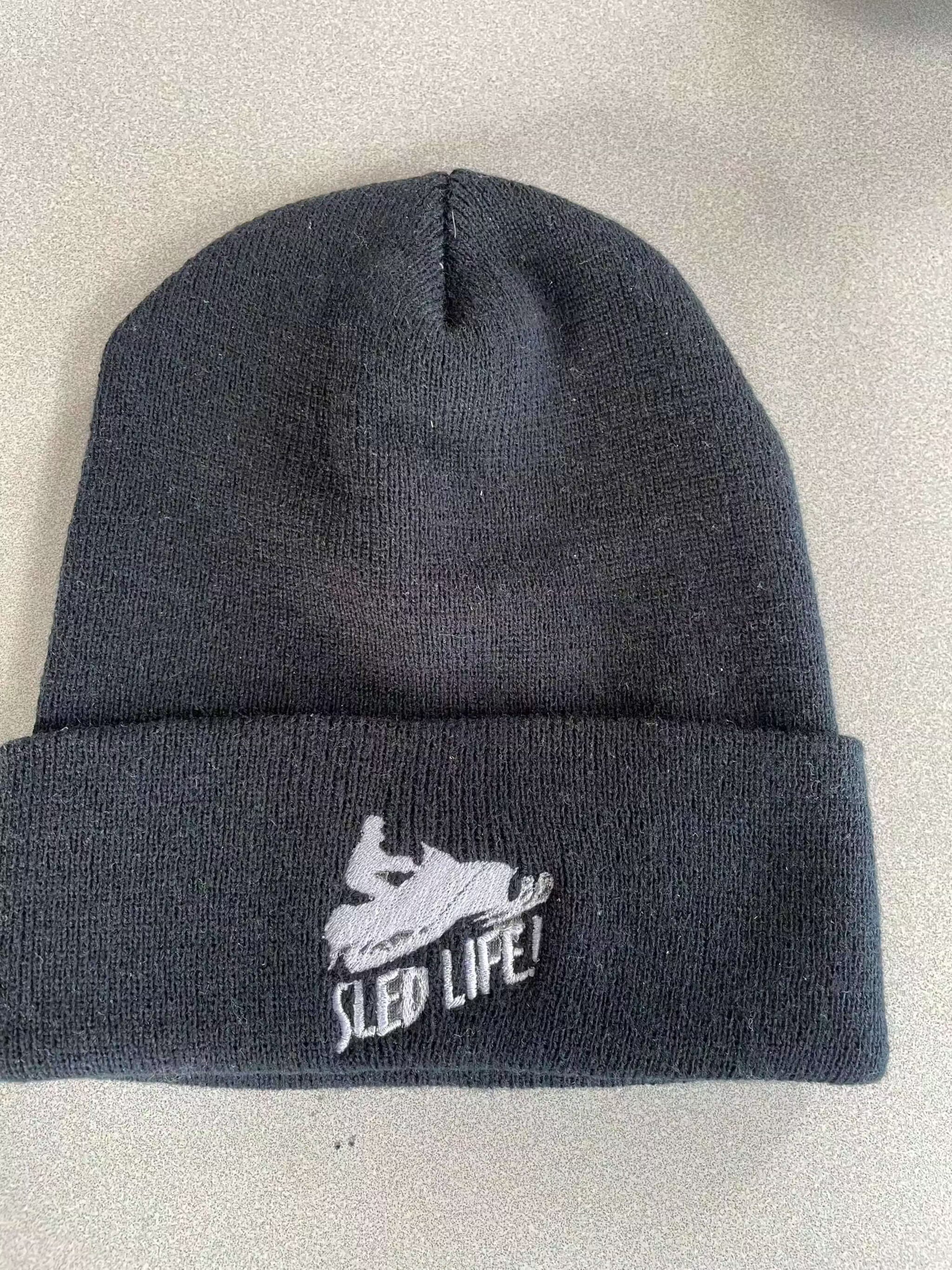 Black warm knit hat with embroidered "Sled Life" logo and cuffed design