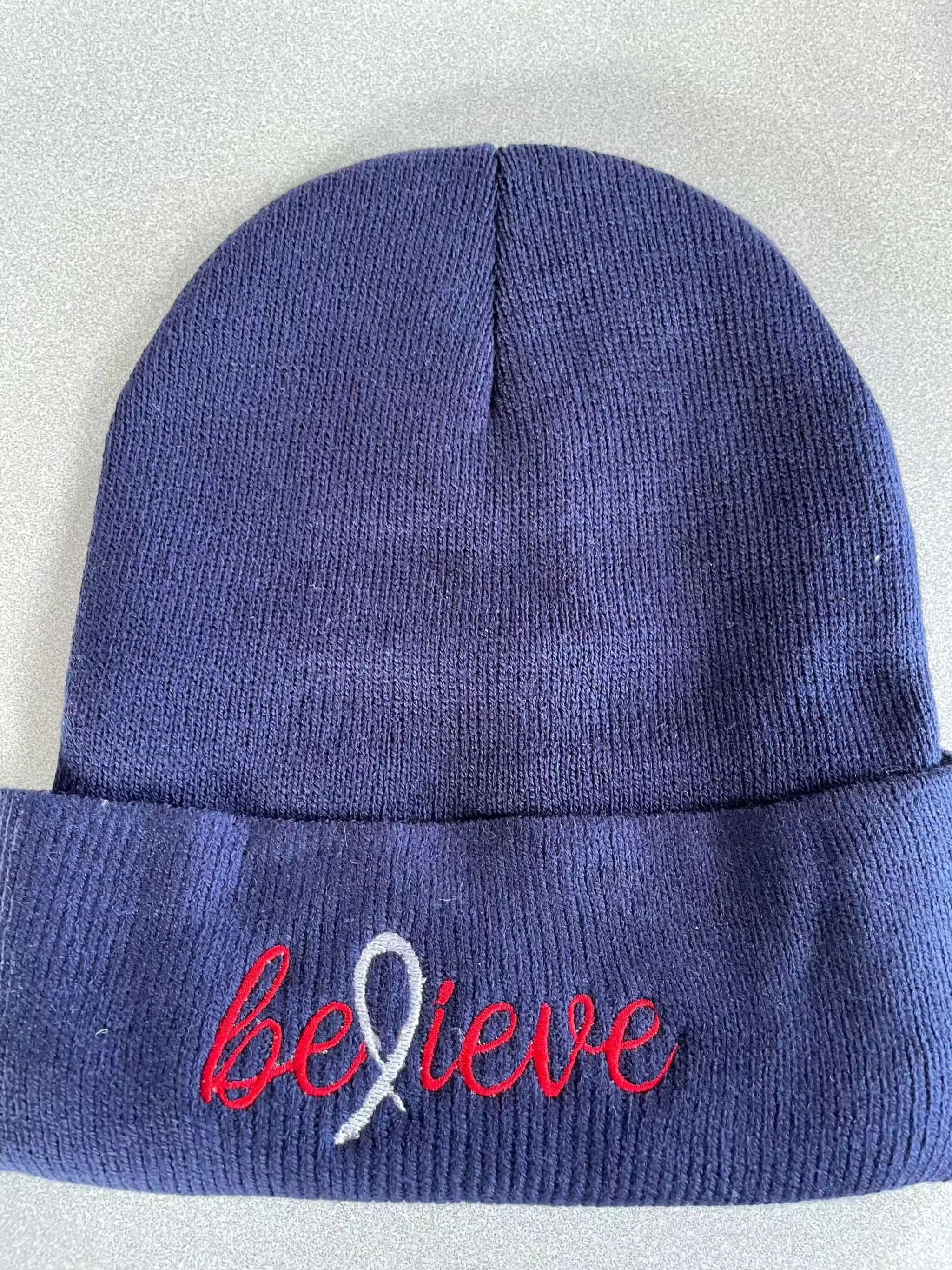 Navy warm knit hat with embroidered believe logo and ribbon design