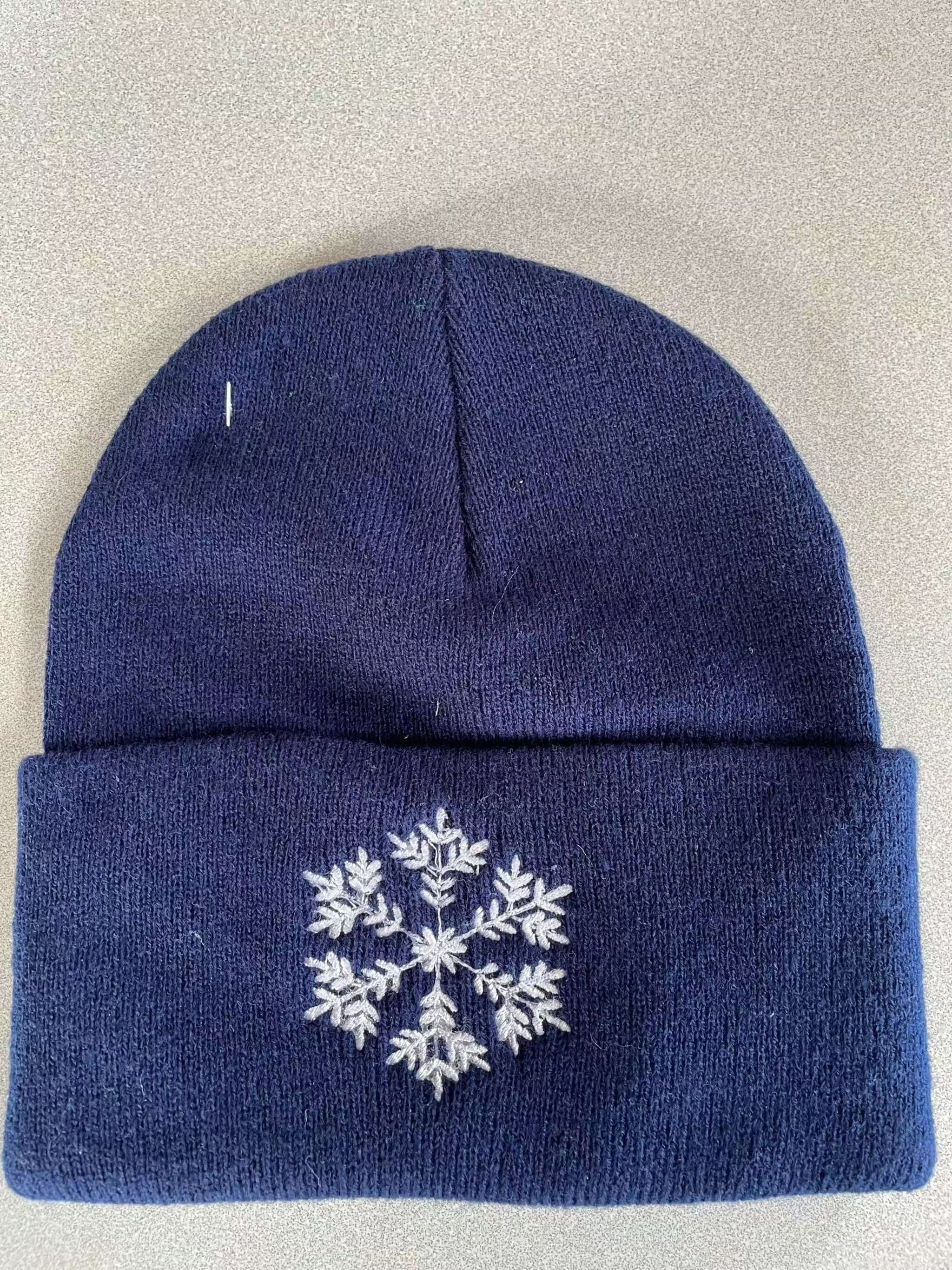 Navy blue warm knit hat with white snowflake embroidery, cuffed design for winter warmth and comfort