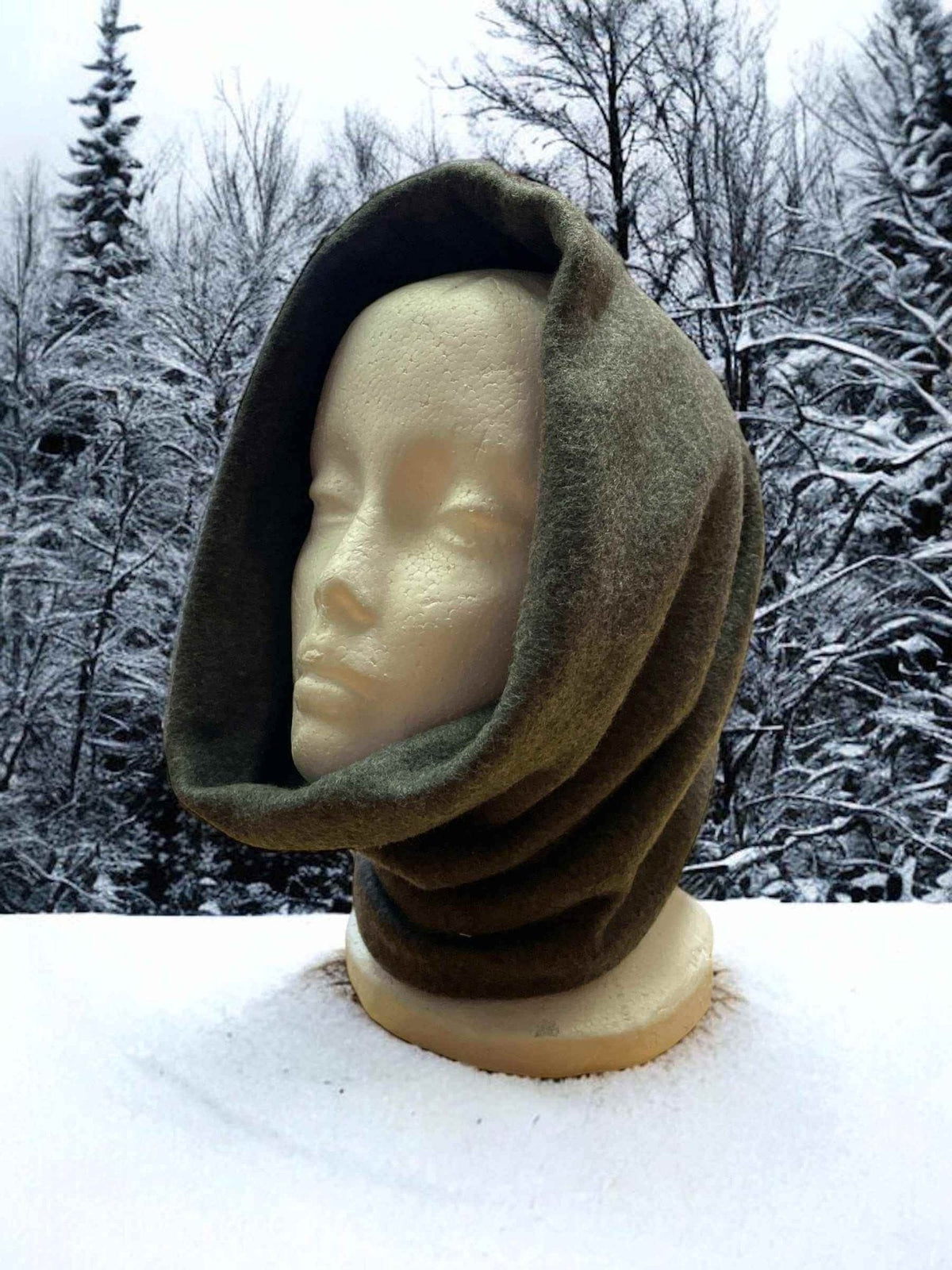 Fleece neck warmer in green Alpine fleece on mannequin with snowy forest background