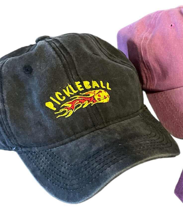 Black embroidered pickleball hat with flames design and purple embroidered pickleball hat