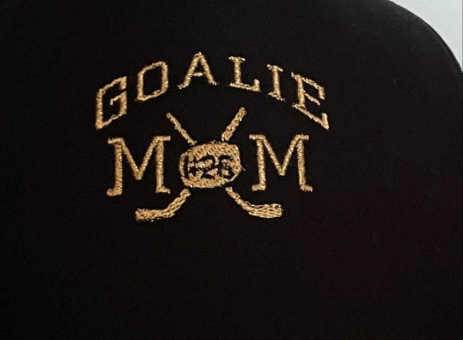 Black baseball hat with embroidered "Goalie Mom" text and personalized hockey puck number for hockey mom fans
