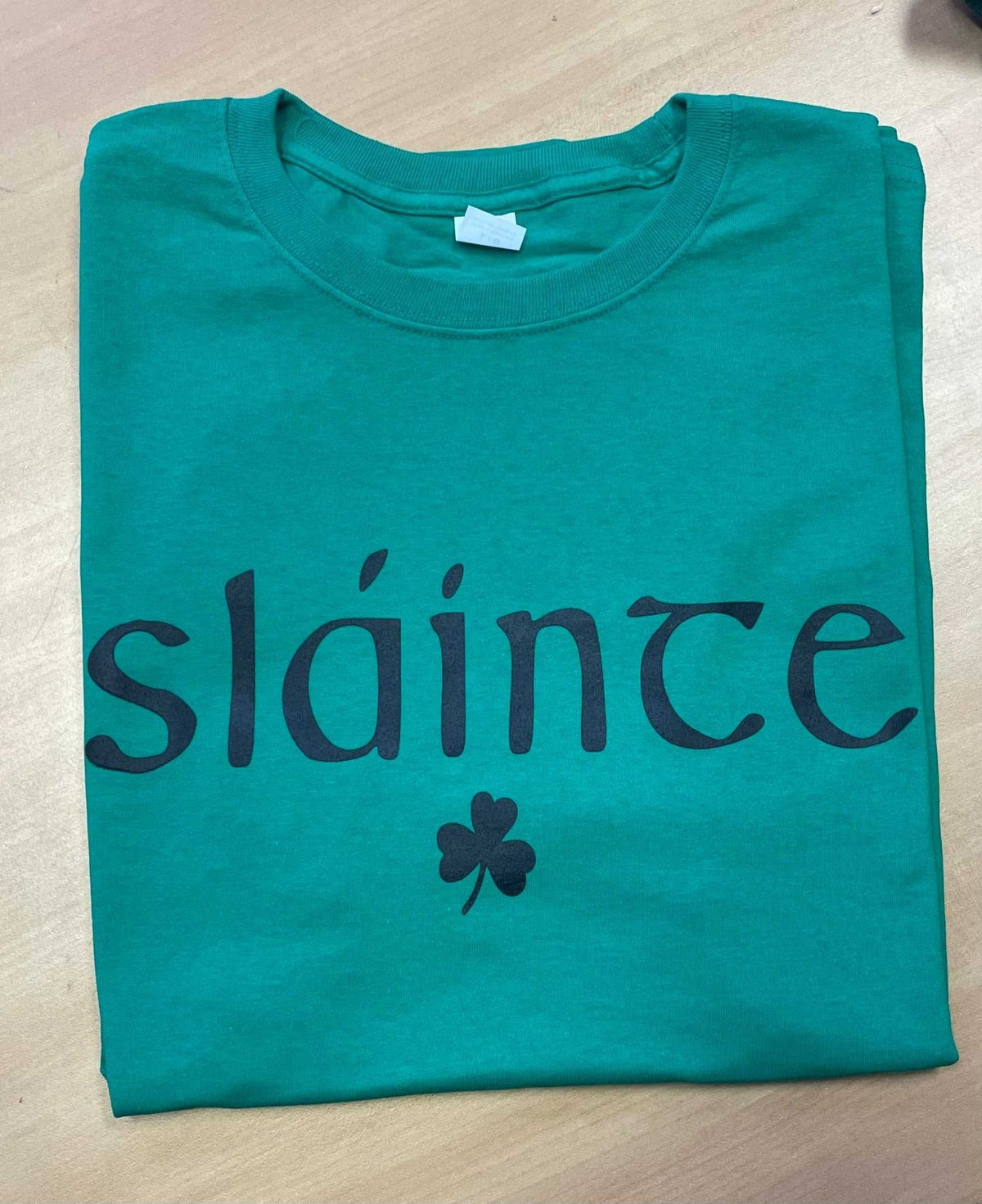 Green cotton t-shirt with black "sláinte" text and shamrock print, Irish blessing tee