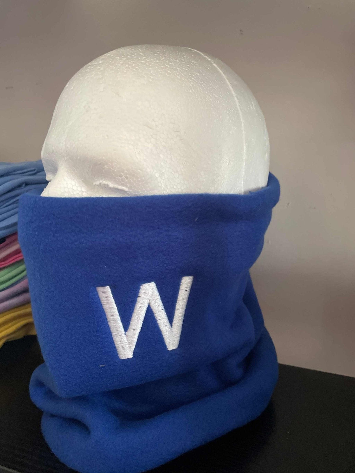 Blue Varsity Fleece Neck Warmer with embroidered white "W" for cold weather sports